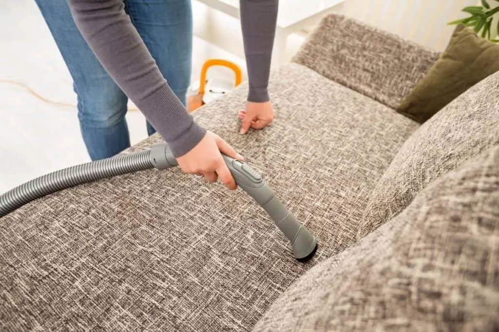 woman vacuuming couch