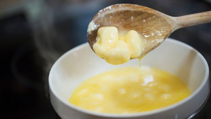 Melted butter dripping from a wooden spoon to a bowl