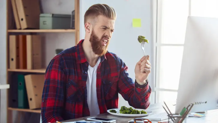Male eating broccoli