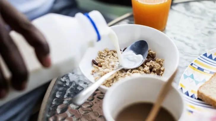 Pouring milk into a bowl of cereal