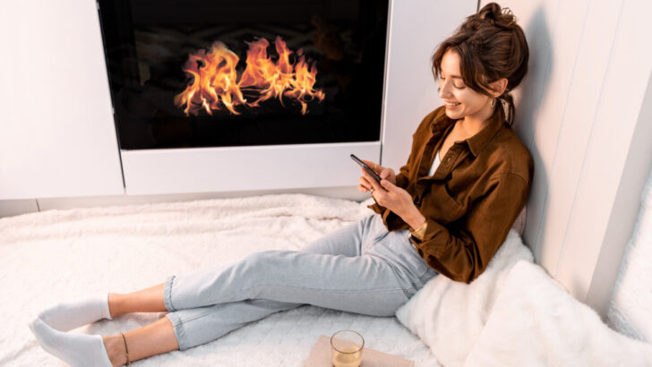 Woman relaxing in front of electric fireplace