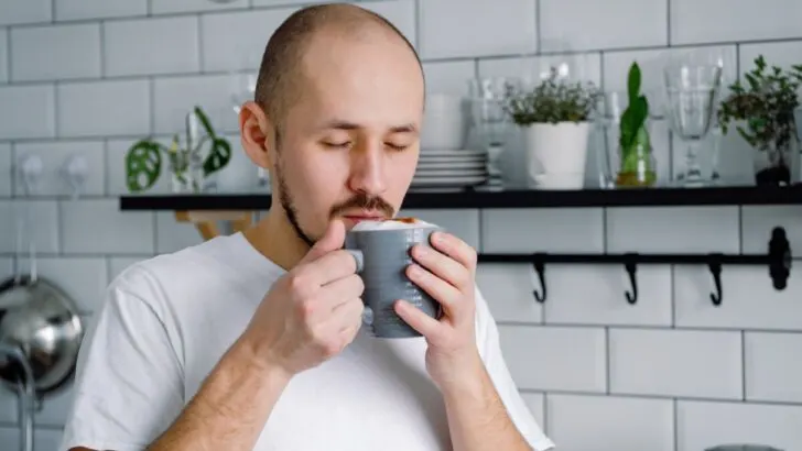 Male smelling coffee with creamer