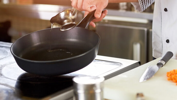 pouring oil in pan over induction stove