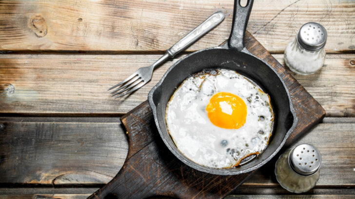 Fried egg in a pan with salt and pepper