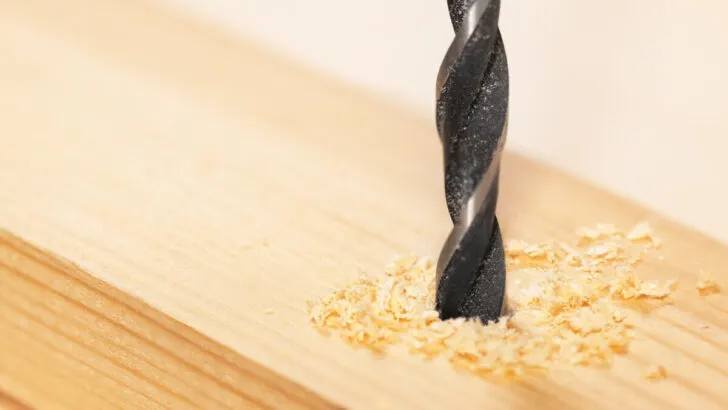 Metal drill bit make holes in a wooden plank