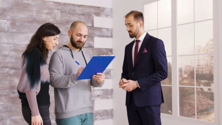 Young couple becoming homeowners after signing document